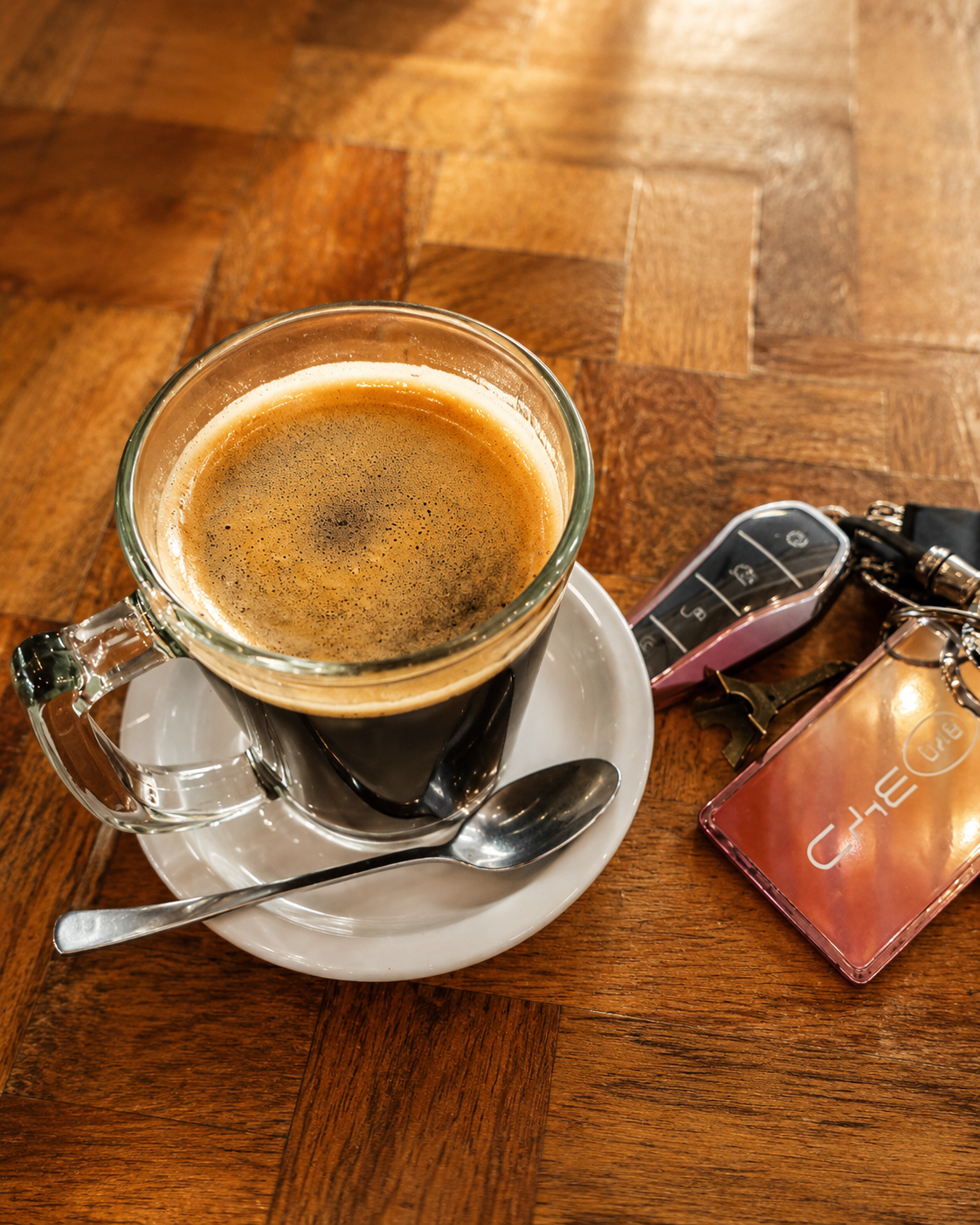 Black coffee espresso in a glass cup on a wooden herringbone table at Annipie Davao